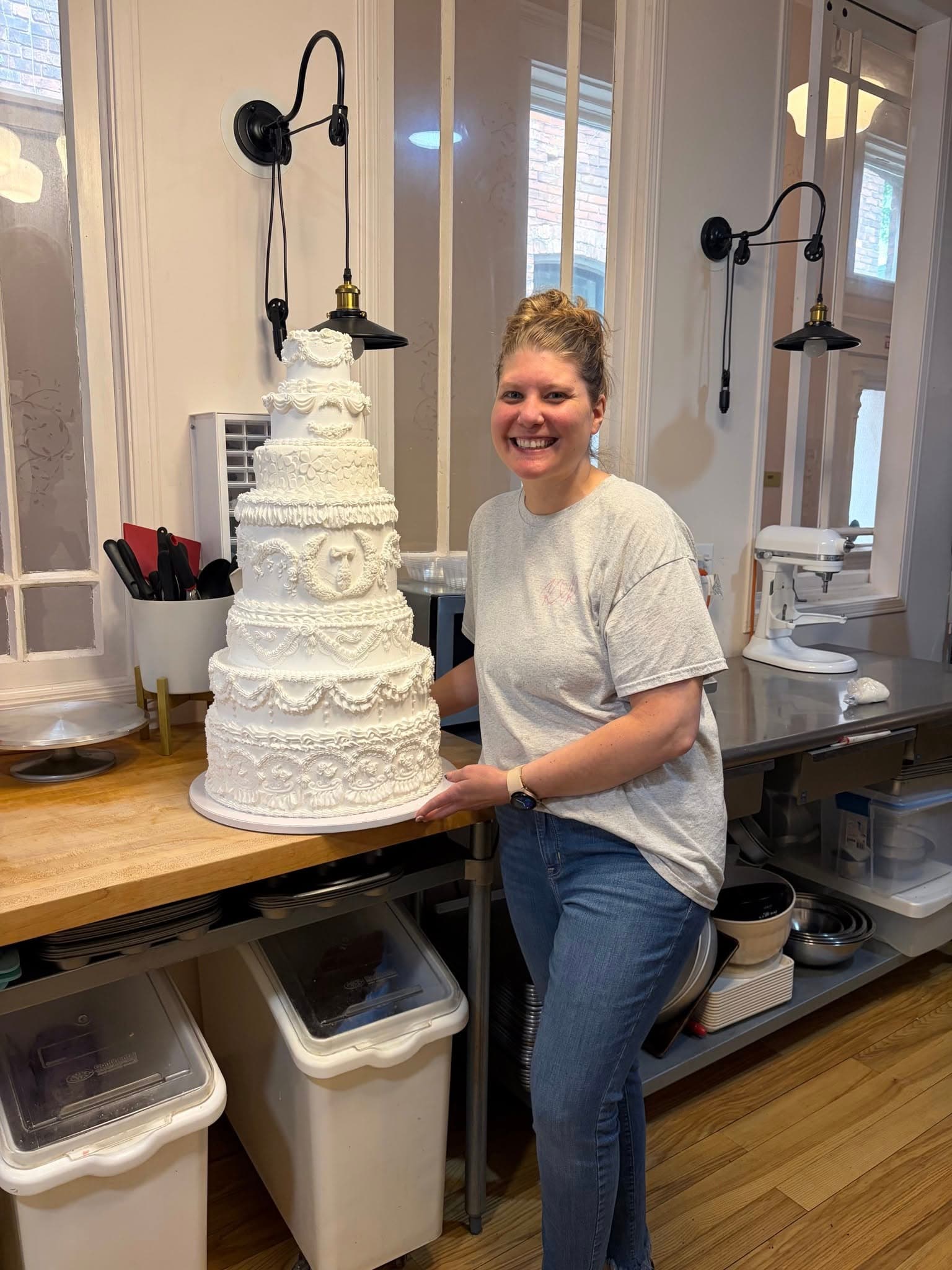 The baker beside an intricately decorated tiered cake at Kay & Rose